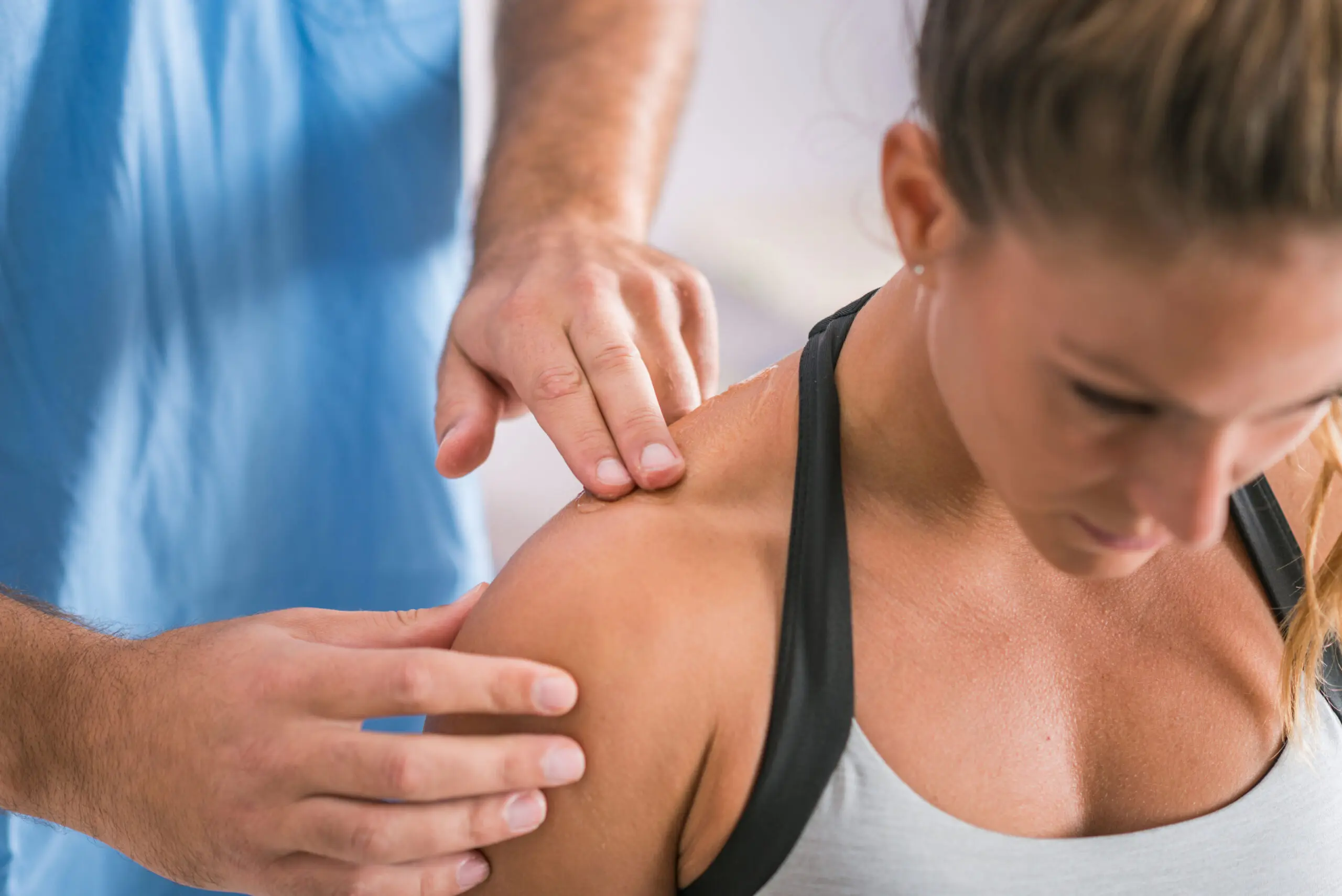 Physical therapist examining a woman's shoulder