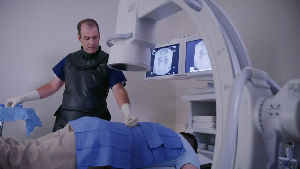 Iowa Ortho interventional pain management doctor Dr. Thomas Klein performing an image-guided spinal injection using fluoroscopy.