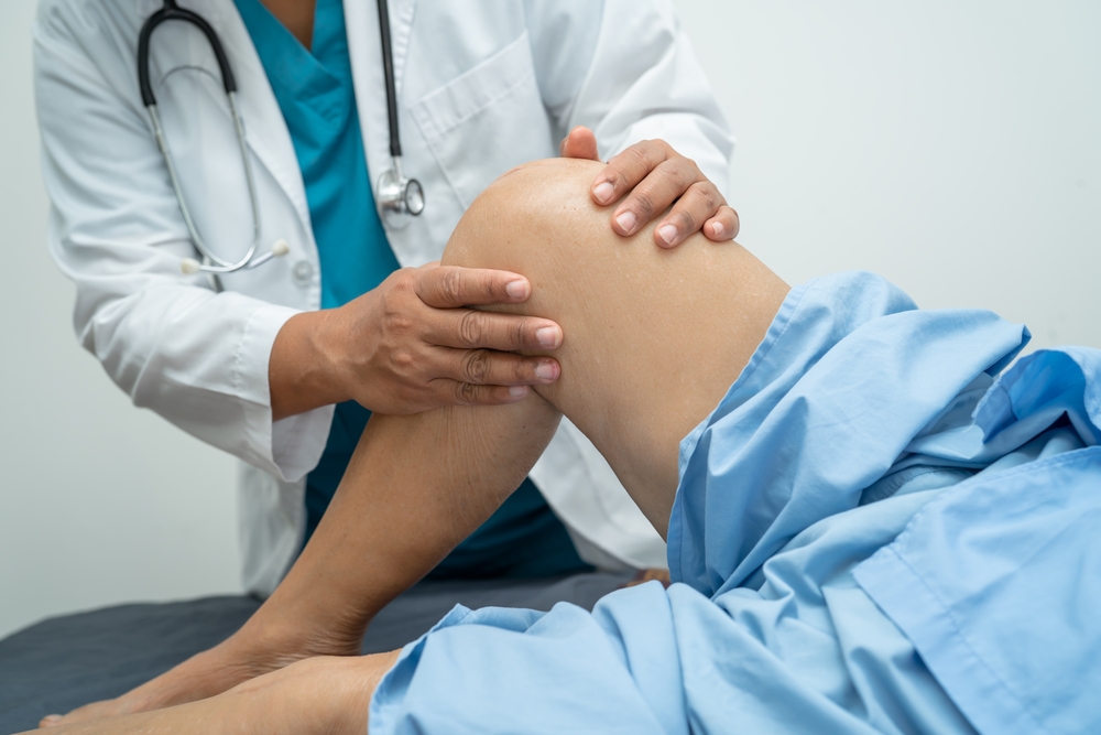 orthopedic surgeon evaluates a patient before a knee replacement surgery
