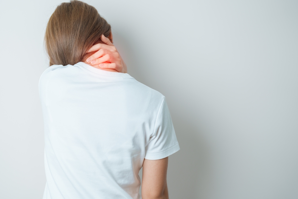 Person experiencing neck pain, possibly due to a musculoskeletal or joint issue